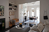 Living room in shades of grey with open doorway leading into dining room in period building