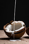 Coconut milk pouring in a halved coconut