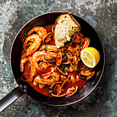 Cooked Vongole Clams and pink Prawn Shrimp with tomato sauce and parsley in cooking pan