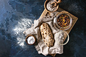 Wholegrain dough stollen preparation on linen napkin with bowls of flour and raisins