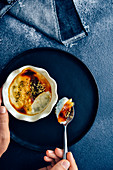 Woman eating baked rice pudding in a white bowl served