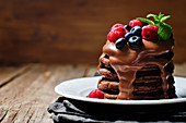 Chocolate pancake with blueberries, raspberies and chocolate sauce