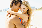 A young couple hugging on a beach