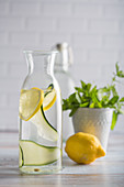 Detox-Wasser aromatisiert mit Zitrone, Gurke und Minze in Glaskaraffe