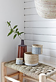 Decorative baskets made from natural fibres on stool with woven seat