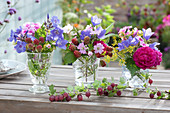 Kleine Sträuße aus Rosen, Glockenblumen, Phlox, Malven und Brombeeren