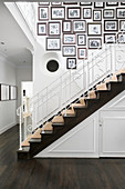 Framed black-and-white family photos on white wall above staircase