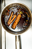 Syrup with spices in a saucepan (top view)