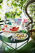 Sommersalat mit Burrata, gegrillten Nektarinen und Parmaschinken, im Hintergrund Roséwein und Wassermelone