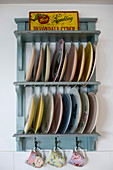 Colourful plates and floral cups on blue, vintage-style plate rack