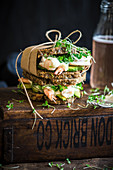 Prawn sandwich on a crunchy health bread with kombucha in the background
