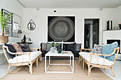 Rattan sofas, coffee table and black leather couch in living room