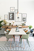 White dining table and shell chairs in front of rustic workbench in dining room