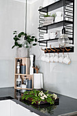 Crockery on shelves and pendant lamp above black worksurface