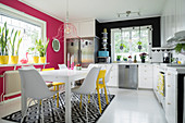Modern kitchen-dining room with bright pink and yellow accents