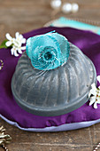 Turquoise fabric flowers on small bundt-cake tin