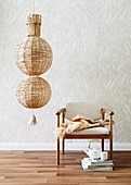 Ceiling lamp made of raffia balls next to an upholstered chair