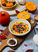 Millet and pumpkin porridge, served with pomegranate seeds and blueberries