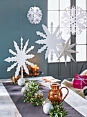 Paper snowflakes and stars hanging above a table
