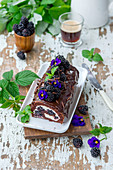 Chocolate roll with cream and blackberries