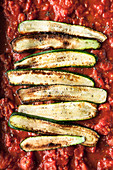 Fried courgette slices on tomato sauce