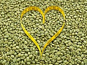 Green coffee beans and heart shape tape measure