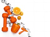 Healthy fruit and vegetables with dumbbells