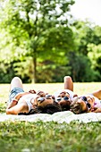 Girls lying on blanket in park