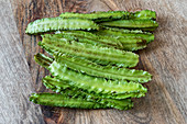 Fresh winged beans on a wooden surface