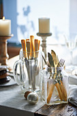A jug and a screw-top jar as cutlery holders on a table laid for Christmas