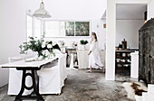 Weiße offene Küche im Vintage-Stil mit Esstisch und Hussenstühlen