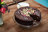 Chocolate cake decorated with pistachio s and rose petals