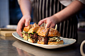 A chef plating up Burgers