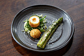 Deep fried boiled egg served with Asparagus and parmesan