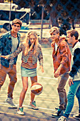 A group of young people wearing fashionable clothing playing basketball