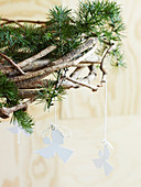 Hanging wreath of coniferous branches with homemade angel pendants