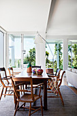 Dining table in a light-flooded beach house with floor-to-ceiling windows