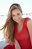 A young blonde woman wearing a red dress