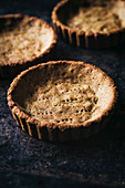 Small tart shells with fork marks on moody background