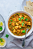 Cottage cheese and pea curry in a ceramic dish (Matar paneer, India)