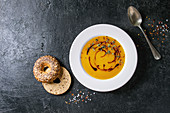 Plate of vegetarian pumpkin carrot soup decorated by balsamic vinegar and thyme