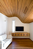 Undulating, wood-clad ceiling in living room