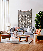 Gray upholstered sofa with pillows, coffee table, armchair and chair as storage furniture