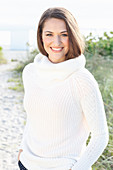 Brunette woman wearing white knit sweater