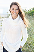 Brunette woman wearing white knit sweater