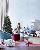 Woman sitting in the Christmas living room with wrapped presents