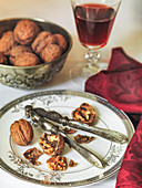 Christmas walnuts cracked open on plate with nut cracker and red wine