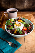 A rice bowl with poached eggs and bacon