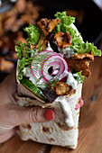 A wrap with chanterelle mushrooms, beetroot, cucumber, onions and goat's cheese