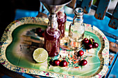 Cherry juice with limes and oranges being filled into bottles